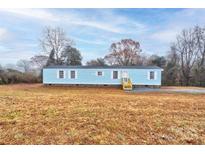 Light blue single-wide mobile home with stone accents and a yard at 2124 Mcbrayer Springs Rd, Shelby, NC 28150