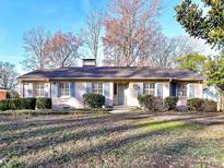 Brick ranch house with blue shutters, landscaped yard, and a spacious lawn at 4720 Aspen Ct, Charlotte, NC 28210