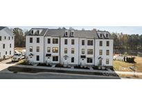 Three-story townhouses with white siding, gray roofs, and small front yards at 13005 Moon Rd # 43, Charlotte, NC 28277