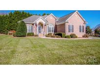 Brick home with a landscaped lawn and large windows at 131 Quail Haven Dr, Troutman, NC 28166