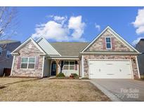 Two-story home with stone accents and a two-car garage at 136 Kingston Dr, Mount Holly, NC 28120