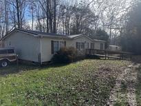 Tan mobile home with ramp access and a spacious yard at 525 Ridgeland Dr, Cleveland, NC 27013