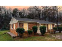 Brick ranch house with landscaped yard and a well-maintained lawn at 733 Milan E Rd, Charlotte, NC 28216