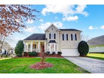 Two-story house with beige siding, a large front porch, and a two-car garage at 7750 Trailridge Dr, Tega Cay, SC 29708