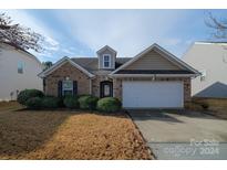 Brick ranch home with attached garage and landscaped yard at 5003 Elementary View Dr, Charlotte, NC 28269