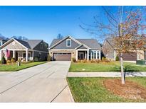 Gray craftsman style home with stone accents and landscaping at 5019 Pleasant Run Dr, Matthews, NC 28104