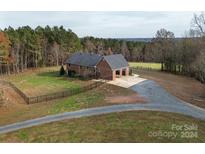 Brick ranch home with detached garage and expansive fenced backyard, offering a tranquil country setting at 7812 Hwy 742 Hwy, Marshville, NC 28103
