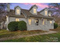 Two story home with white brick exterior, landscaping, and a walkway at 8478 Rocky River Rd, Harrisburg, NC 28075