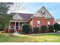 Brick house with a gable roof, front porch, and landscaping at 901 Huntington Hills Dr, Lincolnton, NC 28092