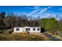 Single-story home with light beige siding, a brick base, and a covered deck at 145 Eastgate Dr, Statesville, NC 28625