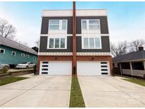 Modern two-story duplex with white garage doors and a wood accent at 327 Coxe Ave, Charlotte, NC 28208