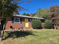 Charming brick ranch home with a yellow door and a welcoming front yard at 72 Marshdale Sw Ave, Concord, NC 28025