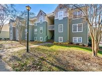 Green two-story townhouses with white-trimmed windows and landscaping at 20105 Henderson Rd # J, Cornelius, NC 28031