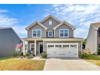 Charming two-story home with a welcoming front porch and attached two-car garage at 1051 Barnette Farm Ln, Monroe, NC 28110