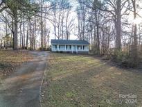 Charming home nestled among trees with a paved driveway and covered front porch at 121 Pam Dr, Gastonia, NC 28056
