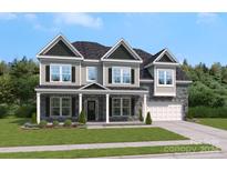 Exterior of a two-story house with a front porch, gray siding, and landscaping at 128 Balboa St # 25, Matthews, NC 28104