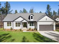 Single-story home with gray and white exterior, two-car garage, and landscaped lawn at 5147 Star Magnolia Rd, Clover, SC 29710