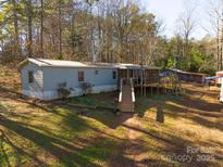 Mobile home with deck and ramp access, nestled in a wooded area at 5040 Spicewood Dr, York, SC 29745