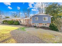 Ranch style home with brick and gray siding, landscaping, and a spacious yard at 3801 Bellevue Ter, Gastonia, NC 28056