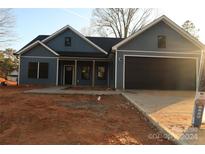 Newly constructed home featuring blue siding, a black garage door, and a covered porch at 635 E Ridge Rd, Salisbury, NC 28144