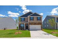 Two-story home with a stone and siding exterior, front-entry garage, and landscaped yard at 108 Rustling Waters Dr, Mooresville, NC 28117