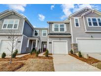 Attractive two-story townhome with gray siding, white garage doors, and landscaping at 2735 Texana Ct, Charlotte, NC 28269