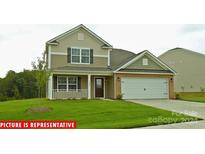 Charming two-story home with a front porch, attached garage, and landscaped yard at 521 Zermatt Ct, Monroe, NC 28112