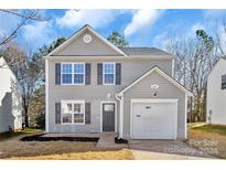 Two-story house with gray siding, a white garage door, and a small front yard at 938 Grassy Patch Ln, Charlotte, NC 28216