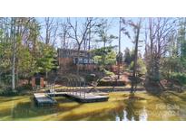Aerial view of waterfront home with private dock and lush landscaping at 60 Sigmon Drum Rd, Hickory, NC 28601