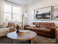 Bright living room features a brown leather sofa and a large window at 1526 Levy Way, Charlotte, NC 28205