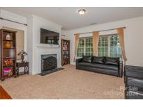 Living room with fireplace, large TV, and comfortable seating at 16718 Dolcetto Way, Charlotte, NC 28277
