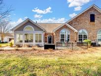 Rear view of charming ranch home with sunroom, patio, and fenced yard at 132 Lone Oak Cir, Rock Hill, SC 29732