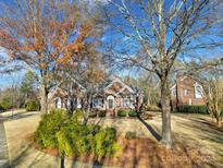 Brick home with mature trees and landscaping at 12104 Darby Chase Dr, Charlotte, NC 28277