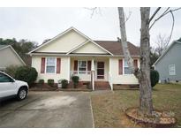 Cute yellow house with red accents, a small front yard, and a driveway at 2038 Mallard Creek Dr, Rock Hill, SC 29732