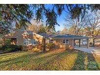 Brick ranch home with a covered carport and well-manicured lawn at 634 Colston St, Albemarle, NC 28001