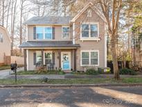 Two-story house with light brown siding, a blue front door, and a small porch at 7004 Mclothian Ln, Huntersville, NC 28078