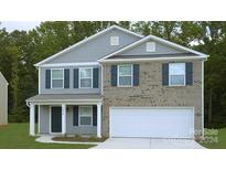 Two-story house with gray siding, brick accents, and a white garage door at 5059 Beargrass Dr, Dallas, NC 28034