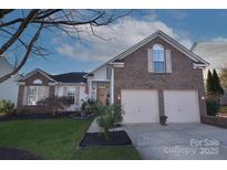 Brick ranch home with two-car garage and landscaped yard at 5661 Cambridge Bay Dr, Charlotte, NC 28269