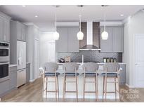 Modern kitchen with gray cabinets, island, and stainless steel appliances at 5684 Clear Creek Ln, Charlotte, NC 28215