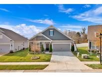 Gray exterior of charming craftsman style home with two car garage, and well manicured lawn at 143 Cup Chase Dr, Mooresville, NC 28115