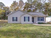 One-story house with light beige siding, dark shutters, and a landscaped lawn at 2151 Pacer Rd, Lancaster, SC 29720