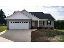 Gray house with white accents, two-car garage, and a brick front porch at 118 Cypress Acres Ln, Statesville, NC 28625