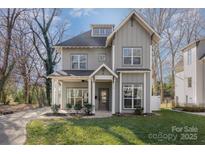 Two-story house with gray siding, a front porch, and a landscaped lawn at 419 Sylvania Ave, Charlotte, NC 28206