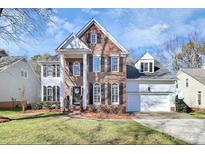 Two-story brick home with a white trim, shutters, and a two-car garage at 7219 Fortrose Ln, Charlotte, NC 28277