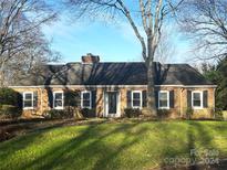 Brick ranch house with a landscaped lawn and mature trees at 5706 Wadebridge Cv, Charlotte, NC 28210