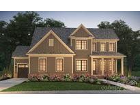 Two-story home with brown siding, brick accents, and landscaped front yard at 14016 Camden Close Cir # 34, Huntersville, NC 28078