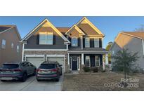 Two-story house with gray siding, stone accents, and a two-car garage at 12825 Franklin Square Rd # 132, Charlotte, NC 28213