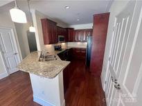 Granite countertops and dark wood cabinets in this updated kitchen at 6605 Central Pacific Ave, Charlotte, NC 28210