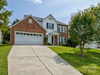 Brick and white two-story house with a two car garage and landscaped lawn at 2015 Mallard Pine Ct, Charlotte, NC 28262