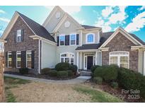 Two-story house with stone and siding exterior, landscaping, and a walkway at 1535 Withers Dr, Denver, NC 28037